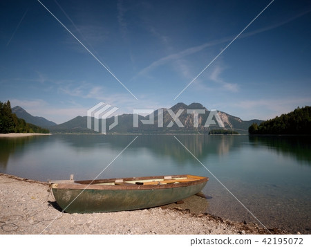 Abandoned fishing boat on bank of Alps lake. Abandoned fishing boat on bank of Alps lake. 42195072