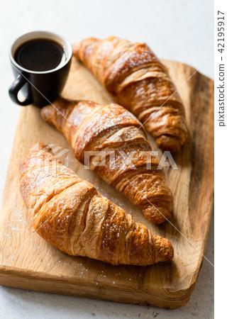 Croissants and coffee on wooden board 42195917