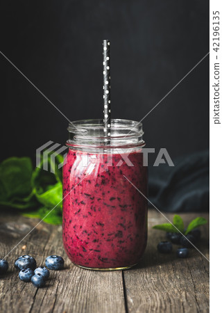 Acai smoothie in bottle on wooden table Acai smoothie in bottle on wooden table 42196135
