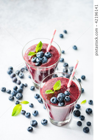 Acai blueberry smoothie in glass with drinking straw 42196141