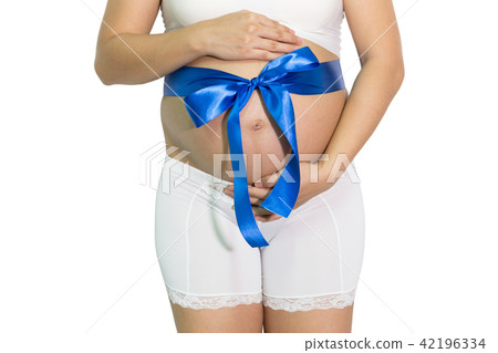 Pregnant woman hands holding belly with blue ribbon gift on bell 42196334