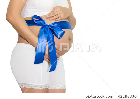Pregnant woman hands holding belly with blue ribbon gift on bell 42196336