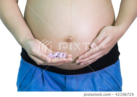 Pregnant woman 40 weeks holding calcium vitamin medicine on hand 42196729