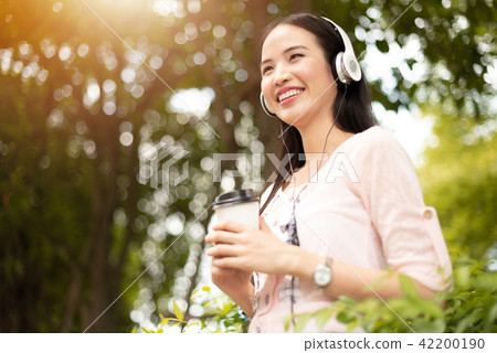 Asian Girl listening to the music with headphone. Asian Girl listening to the music with headphone. 42200190