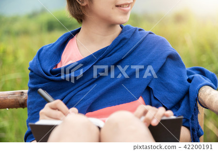 Woman writing in a notebook Woman writing in a notebook 42200191