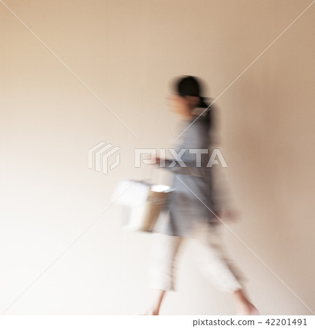 拿著清潔工具和走在屋子裡的婦女 42201491