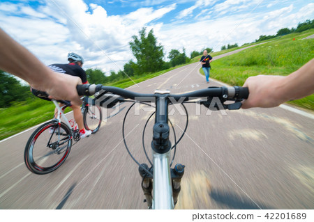 Rider driving bicycle on an asphalt road. Rider driving bicycle on an asphalt road. 42201689