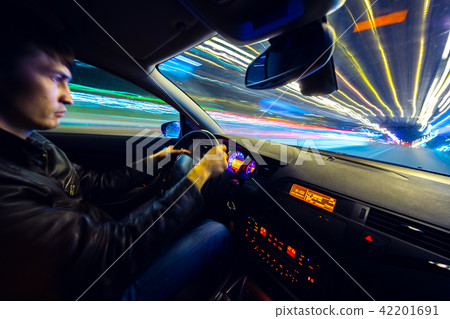 Driver in car moves at fast speed at night. Driver in car moves at fast speed at night. 42201691