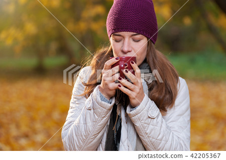 Beautiful woman drinking coffee on fall nature 42205367