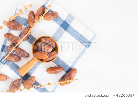 Dates fruit in wooden ladle on white background Dates fruit in wooden ladle on white background 42206384