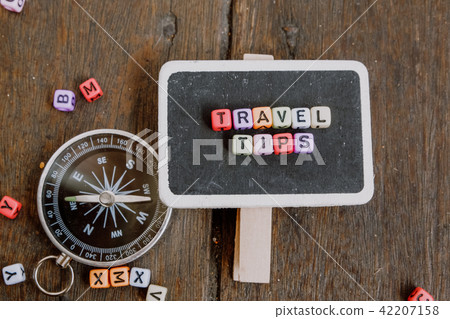 TRAVEL TIP word block on wooden signage 42207158