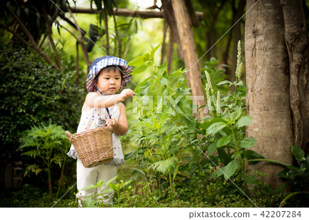 Happy little cute girl in the garden. Happy little cute girl in the garden. 42207284