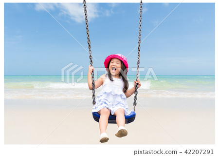 Cute little girl having fun with swing in the park 42207291