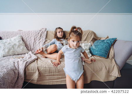 Two little girls in a room on the couch Two little girls in a room on the couch 42207522