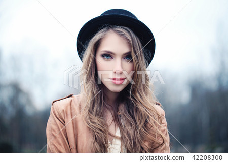 Beautiful young woman outdoors in park 42208300