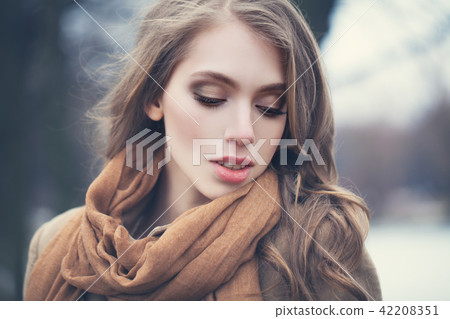 Young woman with long wave brown hair outdoors 42208351