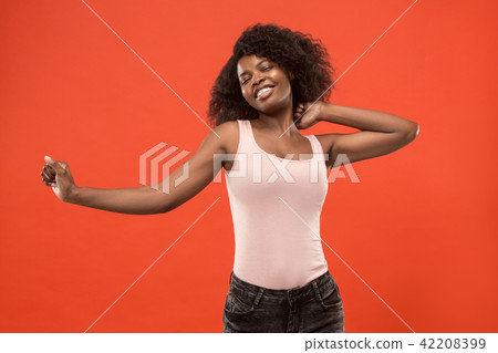 The happy business woman standing and smiling against red background. The happy business woman standing and smiling against red background. 42208399