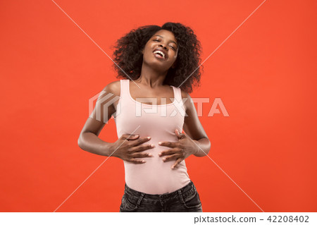 The happy business woman standing and smiling against red background. 42208402