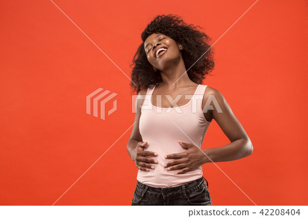 The happy business woman standing and smiling against red background. 42208404
