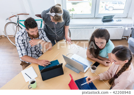 High-angle view of four proficient digital nomads sharing ideas  42208948