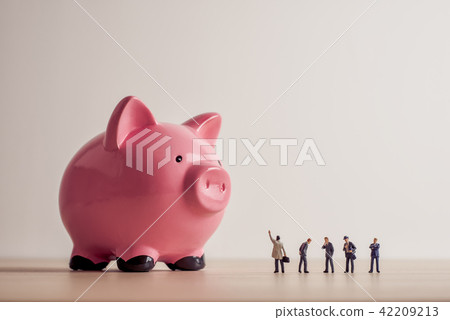 Business people looking at giant Piggy Bank 42209213
