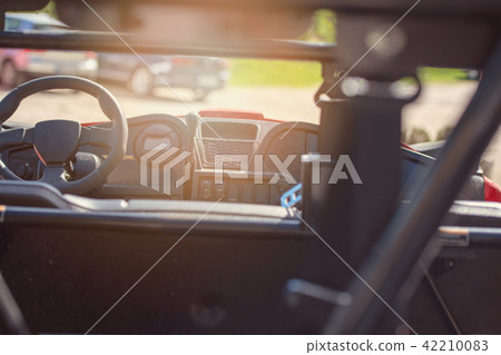 Young people on UTV vehicles on a countryside trail. View from a UTV vehicle with man driving an UTV 42210083