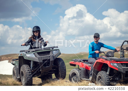 Friends driving off-road with quad bike or ATV and UTV vehicles 42210338