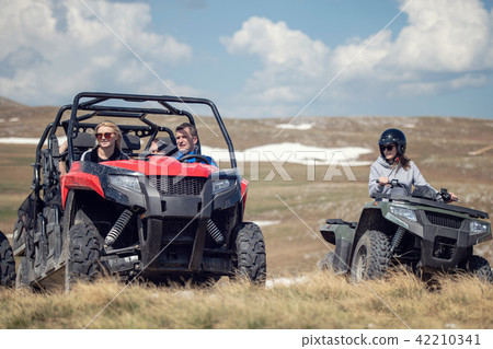Friends driving off-road with quad bike or ATV and UTV vehicles 42210341