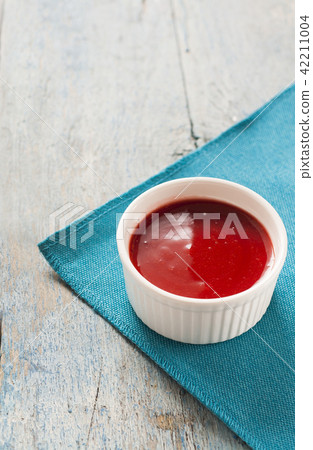 Red sauce in white on a blue background Red sauce in white on a blue background 42211004