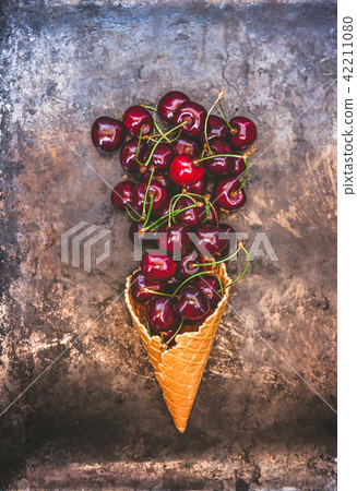 Fresh juicy cherry berries in a waffle cone on Fresh juicy cherry berries in a waffle cone on 42211080