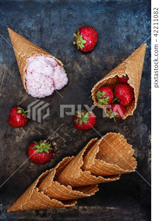 Waffle cone with strawberry ice cream, spoon Waffle cone with strawberry ice cream, spoon 42211082