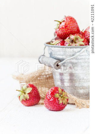 Fresh juicy strawberries in an old iron bucket Fresh juicy strawberries in an old iron bucket 42211091