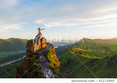 Man standing on top of cliff 42213049