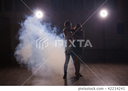 Young couple dancing social danse kizomba or bachata or semba or taraxia in dancing class background 42214241