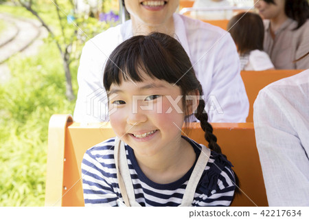A family traveling around the amusement park by train 42217634