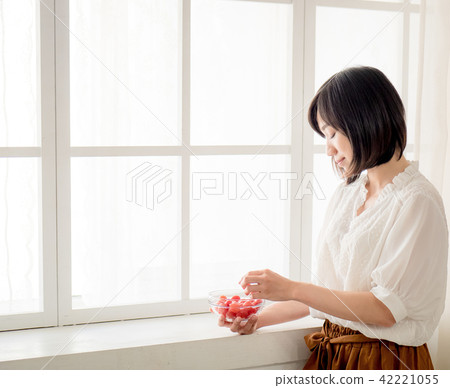 Girl eating fruit by the window 42221055