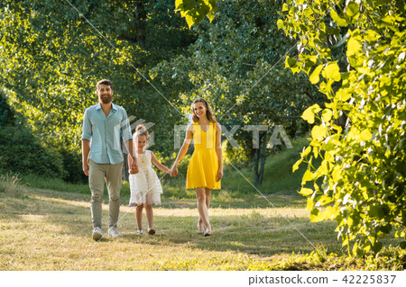 Caring parents holding hands of daughter while walking together in the park Caring parents holding hands of daughter while walking together in the park 42225837