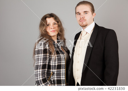 Elegant couple smiling for the camera while embracing. On grey background. Elegant couple smiling for the camera while embracing. On grey background. 42231830