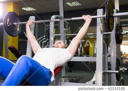 Fitness, athlete, bodybuilding and people concept - Muscular bodybuilder bench press workout 42233180
