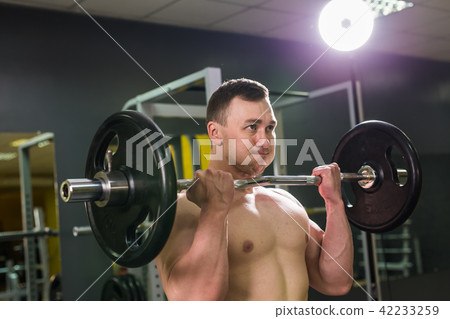 Handsome power athletic man with barbell. Strong bodybuilder with six pack, perfect abs, shoulders Handsome power athletic man with barbell. Strong bodybuilder with six pack, perfect abs, shoulders 42233259