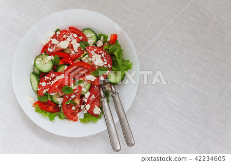 Shopska salad in a white plate on a white tableclo 42234605