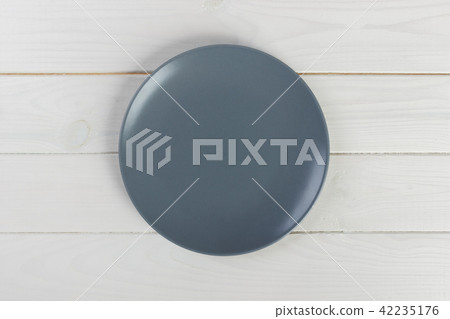 Top view empty round plate on white wooden table Top view empty round plate on white wooden table 42235176