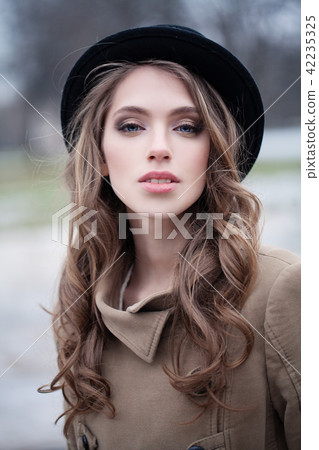 Pretty girl in black hat outdoors, portrait 42235325