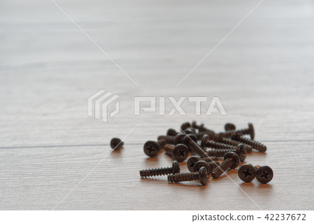 pile of a black screws on wooden background pile of a black screws on wooden background 42237672