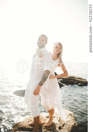 Just married wedding couple walking on the beach at sunset. 42238255