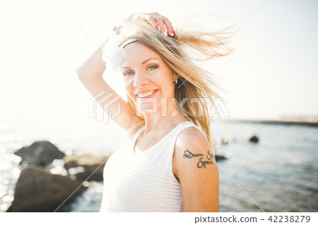 Romantic beautiful bride in white dress posing on the sea stones 42238279