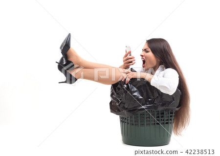 Crazy woman sitting in trash can. 42238513