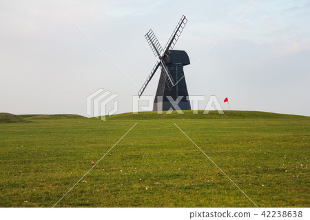Windmill and red flag with green lawn and overcast Windmill and red flag with green lawn and overcast 42238638
