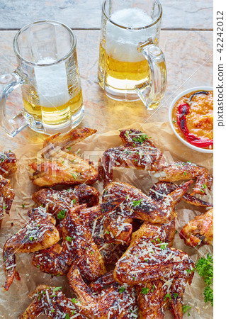 chicken wings, glass cups of beer 42242012