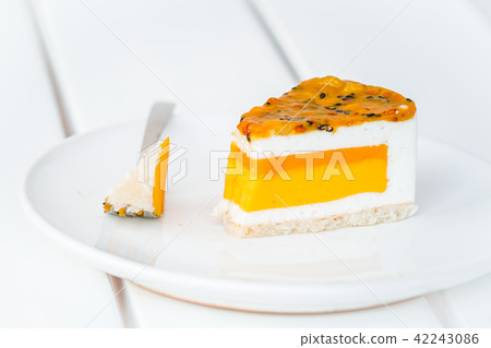 Slice of mango passion fruit coconut cake on white Slice of mango passion fruit coconut cake on white 42243086